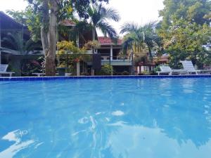 a large swimming pool in front of a house at Lake Side Tourist Inn in Tissamaharama
