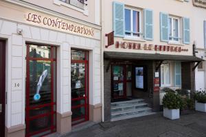 una tienda con puertas rojas en un edificio en Hotel Le Beffroi, en Dreux