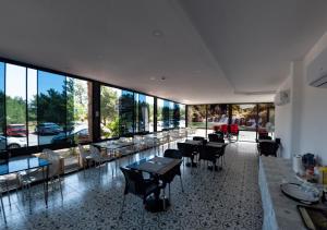 a restaurant with tables and chairs and large windows at REGA OTEL in Antalya