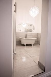 a bath tub in a bathroom with a chandelier at Cottage Buttercup Yarm in Stockton-on-Tees