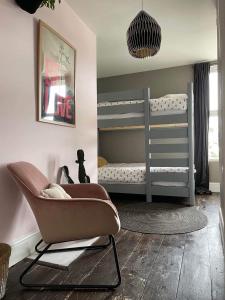 a nursery with a gray bunk bed and a chair at Beautiful Townhouse with Parking Sleeps 6 in Kingsbridge