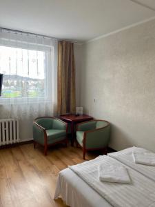 サノクにあるDom Turysty Sanokのベッドルーム1室(ベッド1台、椅子2脚、テーブル付)