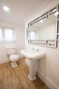 a white bathroom with a sink and a toilet at Cottage Buttercup Yarm in Stockton-on-Tees