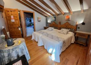 a bedroom with a large bed and a table at Posada Araceli in Santillana del Mar