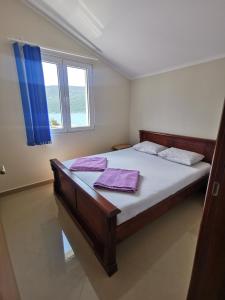 Un dormitorio con una cama con sábanas moradas y una ventana en Apartmani Krivokapic, en Herceg-Novi