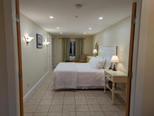 a bedroom with a bed and a table with a lamp at Waterfront ground floor condo Sheepscot Harbour Vacation Club 1 Bedroom Condo #205 in Edgecomb