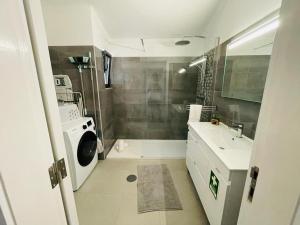bagno bianco con doccia e lavandino di Casa Azinheira 1ºa- Albufeira ad Albufeira