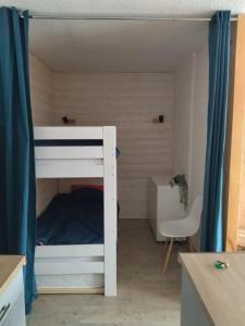 a bunk bed in a room with a desk and a chair at Studio Le Lacuzon avec piscine et tennis extérieurs in Les Rousses