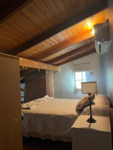 1 dormitorio con 1 cama y 1 lámpara en una mesa en Departamento Pellegrini en Tandil