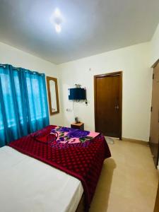 a bedroom with a bed with blue drapes at Hotel Nakshatra in Ooty