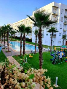 ein Resort mit Palmen und einem Pool in der Unterkunft Les jardins de Bouznika in Bouznika