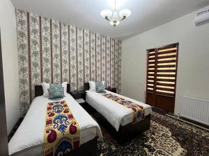 a bedroom with two beds and a window at OLD SAFARI HOTEL make yourself at home in Bukhara