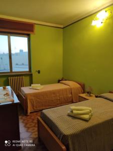 um quarto verde com duas camas e uma janela em CasAda spazioso e luminoso appartamento em Tricase
