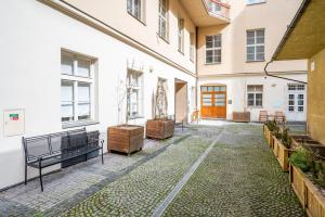 un patio de un edificio con un banco y plantas en Premium Wenceslas Square Apartments, en Praga