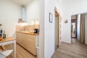 a kitchen with white walls and a wooden floor at Premium Wenceslas Square Apartments in Prague