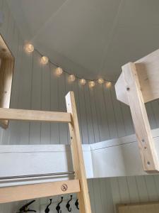 a room with a ceiling with a ladder and lights at Kroghs Tiny Houses - Hyttebyen in Grindsted
