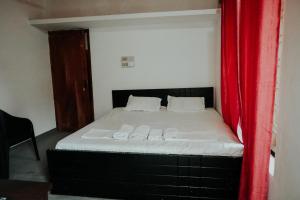 - une chambre avec un lit et un rideau rouge dans l'établissement kaffee valley homestay, à Padinjarathara