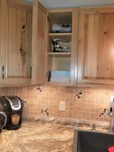 a kitchen with wooden cabinets and a counter top at Your comfy home in Colorado Springs in Colorado Springs