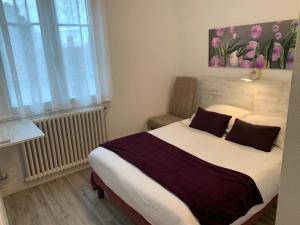 a bedroom with a large bed and a window at Hôtel Le Smile in Saint-Vincent-Sterlanges