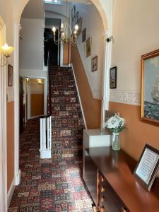 un pasillo con una escalera con una alfombra estampada en The Langham, en Weymouth