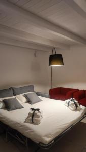 ein großes Bett in einem Zimmer mit einem roten Sofa in der Unterkunft Amalò Guest House in Bari