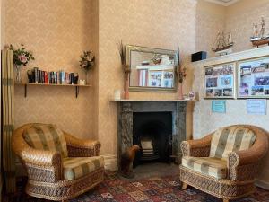 a living room with two chairs and a fireplace at The Langham in Weymouth