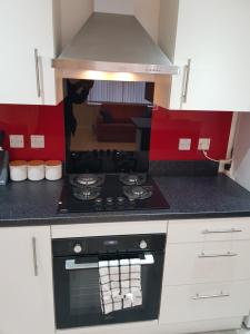 a kitchen with a stove top oven in a room at Central Windsor 2 bedroom flat with free parking in Windsor