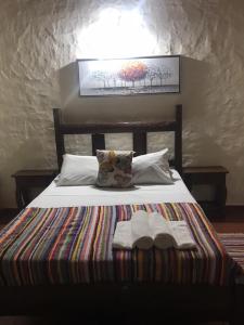 Una cama con dos toallas encima. en Granja Mi Retiro en Areguá