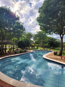 una gran piscina en un parque con árboles en Granja Mi Retiro en Areguá