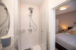 W łazience znajduje się prysznic ze szklanymi drzwiami. w obiekcie Villa Kaliva w mieście Bullay
