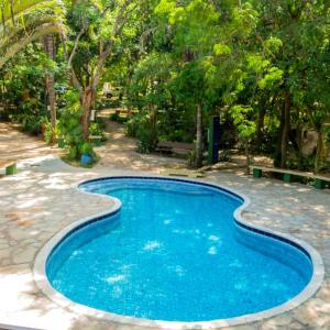 uma piscina num quintal com árvores em Granja Mi Retiro em Areguá