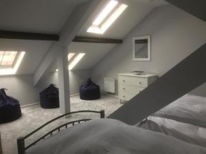 a attic bedroom with a bed and skylights at 40 Newgate Barnard Castle -Central Location - Court Yard - Dog Friendly - Sleeps 7 - Wood Burner - Complimentary Logs & Wine - Smart TV in Barnard Castle