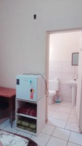 a small refrigerator in a bathroom with a toilet at Hotel Casa Grande Max in Marília