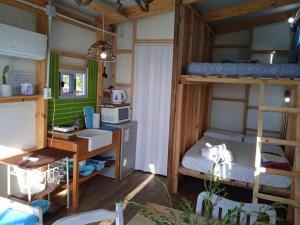 a room with two bunk beds and a desk at Uy MÁGICA Cabaña en entorno Natural único in Mercedes