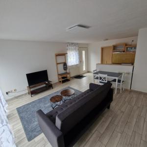 a living room with a black couch and a kitchen at Ferienwohnung Varli in Tuttlingen