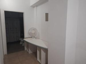 a white room with a desk with a fan at departamento centrico de un dormitorio para tres personas in San Juan
