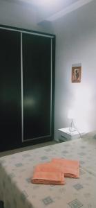 a bedroom with a bed with an orange towel on it at departamento centrico de un dormitorio para tres personas in San Juan