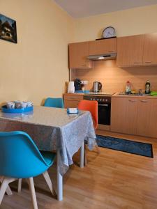 Una cocina con una mesa y sillas en una habitación. en Eigener Eingang, 1-Zimmer mit Bett und große Wohnküche mit Schlafcouch, en Oberhausen
