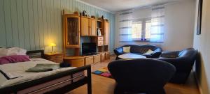 a bedroom with a bed and a couch and chairs at Eigener Eingang, 1-Zimmer mit Bett und große Wohnküche mit Schlafcouch in Oberhausen