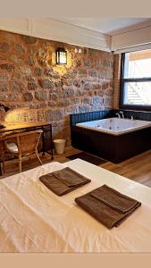 a bathroom with a tub and a bed with towels at Attalos Suites Hotel in Bergama