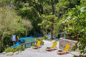 a group of chairs sitting on a patio next to a pool at Buena Vista del Rincón Eco Adventure Park Hotel & Spa in Liberia