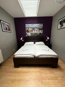 a large bed in a bedroom with a purple wall at Central Studios in Prague