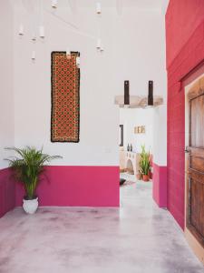 a room with pink and white walls and a door at Binzas betzas Agriturismo in Sedilo