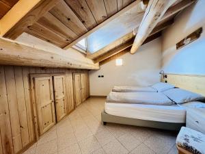 1 dormitorio con 1 cama en una habitación con techos de madera en Chalet Nicolin, en Livigno