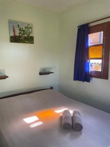 a bedroom with a bed with two slippers on it at Morada Crisálida in Praia do Rosa