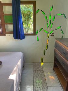 a bedroom with a clock with green birds on the wall at Morada Crisálida in Praia do Rosa