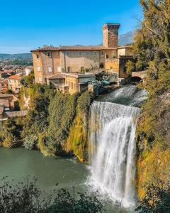 a waterfall in front of a building on a hill at IN CENTRO Rooms and Apartments in Isola del Liri