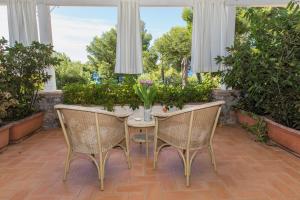 un patio con una mesa con sillas y flores en Hotel Villa Delle Meraviglie, en Maratea