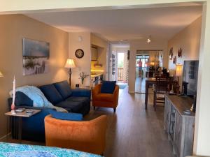 sala de estar con sofá azul y cocina en Sunset Harbor Condo for 2-TOP FLOOR 1-309, Navarre Beach, en Navarre