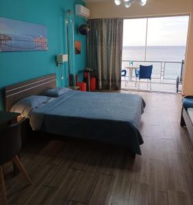 a bedroom with a bed and a view of the ocean at Blue Studios in Chania